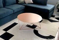 Coffee table shown in living room setting on patterned rug beside sofa, showing overall size and color.