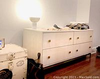 Front view of ivory shagreen embossed dresser with items on top within room setting