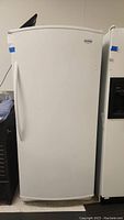 Front exterior view of white upright refrigerator with single door and handle