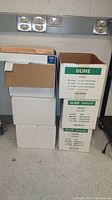 Six boxes stacked, some labeled Uline Stayflats with sizes and types of envelopes indicated.