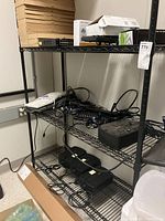 Full shelving unit with electronic devices and boxes on shelves