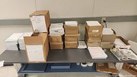 Wide shot of various cardboard boxes and stacks of envelopes and paper on a shelf