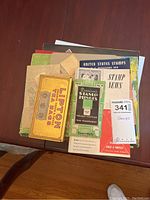 Top view of stamp albums and philatelic items stacked showing vintage stamp hinges package and Lipton tea tins box for stamps storage.