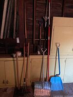 Overview of yard tools including rakes, shovels, and snow shovel