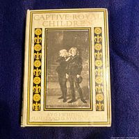 Front cover of Captive Royal Children book with decorative gold and black design and central illustration