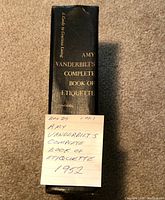 Photo of book spine with title and author Amy Vanderbilt's Complete Book of Etiquette and a note indicating first edition 1952.