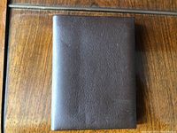 Closed bifold brown leather photo wallet showing front exterior.