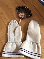 Photo of the pair of white handmade wool mittens with blue stitching, thick soft wool, long cuffs