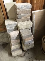 Stack of interlock paving stones with visible variation in color from beige to brown and rust, showing rough textures and different thicknesses.