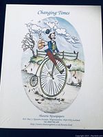 Front view of the white decorative card box with illustration of a man on a penny-farthing bicycle and text 'Changing Times Historic Newspapers' with contact info.