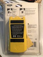 Back view of the yellow Stanley IntelliSensor stud and joist locator showing the operating instructions sticker and model number 77-100.
