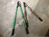 Both pruners side by side showing green and wooden handles with black rubber grips and metal pruning blades.