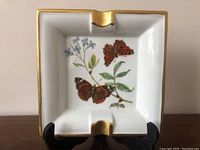 Front view of square porcelain ashtray showing hand-painted butterfly and floral design with gold trimmed edges.