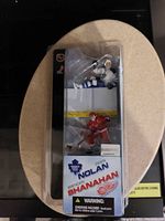 Two hockey player figurines in original packaging showing names Owen Nolan and Brendan Shanahan and NHL team logos.