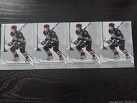 Four front views of Alexander Ovechkin 2006/2007 SP Authentic hockey cards lined up horizontally on a dark wooden surface.