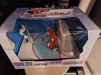 Starting Lineup Freeze Frame One on One Hockey figurine set inside original packaging showing two hockey players posed near a hockey net on a small plastic ice rink.
