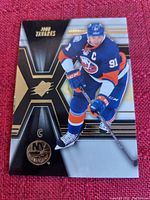 Front side of John Tavares hockey card showing player in New York Islanders uniform with captain C, stylish background and team logo.