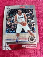 Photo of Kawhi Leonard basketball card from NBA Hoops Premium Stock series, featuring Leonard in Clippers uniform holding a basketball on court, card in lightly used condition.