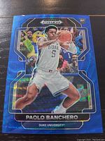 Front view of Paolo Banchero basketball card showing holographic Blue Wave Prism design and action photo of player in Duke uniform.