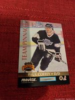 Front image of Paul Coffey hockey card from Team Pinnacle series showing the player in Los Angeles Kings black uniform on ice rink background.