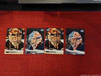Four Upper Deck goalie hockey cards, two featuring Anthony Stolarz and two featuring Stuart Skinner, arranged on a red surface.