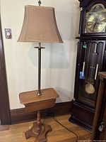 Full view of the floor lamp with attached wooden side table, showing height and overall structure.