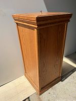 Image showing the left side panel of the wooden bin with visible wood grain and paneled detail.