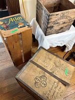 Photo showing three used wooden crates: one with a colorful Atlas label, another with Canadian Suite stencil, and a third with RENOYOL stamp and metal bands.
