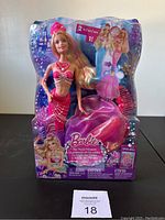Front view of Barbie The Pearl Princess Lumina Mermaid doll in original packaging showing doll with mermaid tail and additional ball gown skirt beneath.