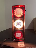 Front view of the tri-light sign lit, showing the top and bottom lights glowing red with 'GO!' text and the middle light showing Montreal Canadiens logo.