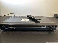 Front view of Sony STR-KS2000 receiver with remote resting on top, showing front controls and branding.