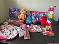 Wide photo of all toys in the lot including plush, magic set, puzzle, Snap Pets, My Little Pony toys, microphone, and coloring pad