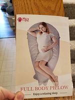 Box photo showing brand Meiz and illustration of a woman using the full body pillow.