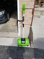 Full view of snow thrower showing its overall structure and broken handle.