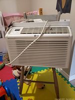 Front view of white LG window air conditioner showing front grille, digital control panel, and power cord.