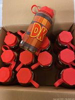 Photo showing multiple Donkey Kong water bottles with red caps inside a cardboard box, one bottle displayed prominently on top.