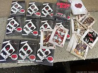 Twelve new and sealed decks of horror-themed playing cards with skull logo on front of box, some cards pulled out to show horror movie characters artwork.