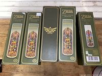 Five boxed Nintendo Legend of Zelda glass candle holders in packaging showing the stained glass artwork and branding.