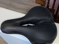 Top view of the black padded bicycle seat showing smooth finish and stitching detail.