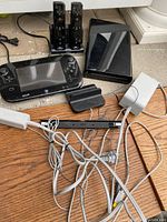 Full view of all included items displaying Nintendo Wii U console, GamePad, two Wii Remotes in charging dock, sensor bar, power adapter, cables, and charging cradle.