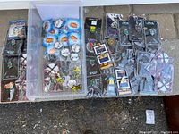 Overview of 51 enamel pins mostly in plastic packages, showing various designs and brands.
