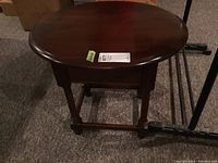 Front view of oval wood table showing overall shape, finish, and legs.