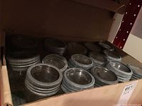 Box of multiple vintage Crown canning jars with metal screw lids seen from above showing multiple lids with embossed Crown logos.