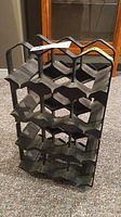 Full view of the black resin wine rack holder showing all 12 compartments.