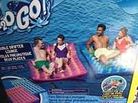 Two people sitting on pink double drifter lounge and two people sitting on blue double drifter lounge floating on water.
