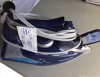 Blue and black Rowenta Steam Force iron with power cord wrapped around it, showing side profile and label stating 'Made in Germany'.