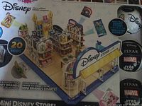 Full box image showing detailed miniature Disney Store setup with shelves and 20 mini figures from Disney brands.