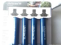 Photo of the four blue LifeStraw personal water filters in packaging, showing the branding and product design.