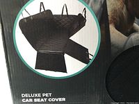Photo of package showing the deluxe pet car seat cover laid out with straps and dimensions noted.