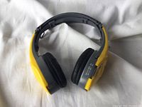 Yellow and black sports radio headphones displayed folded to show ear padding and adjustable headband.